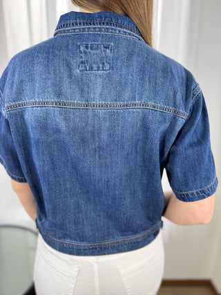 Blue denim jacket worn by a person against a white background