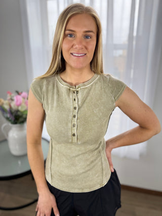 Woman wearing a light green shirt with buttons indoors