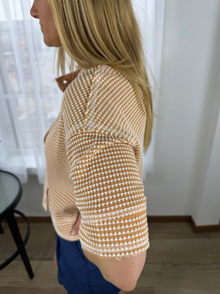 Person wearing a checkered shirt with a blurred background