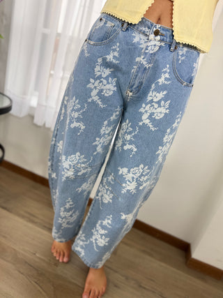 Blue floral-patterned jeans worn by a person indoors.