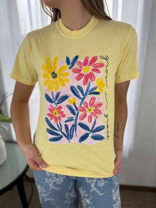 Person wearing a yellow t-shirt with colorful floral design