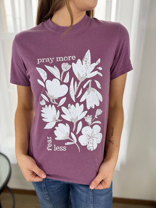 Person wearing a purple t-shirt with floral design and text