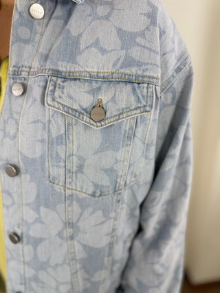 Light blue denim jacket with floral pattern on a neutral background