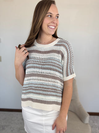 Woman wearing a striped sweater against a plain background