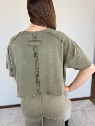 Person wearing a green outfit with a plain background