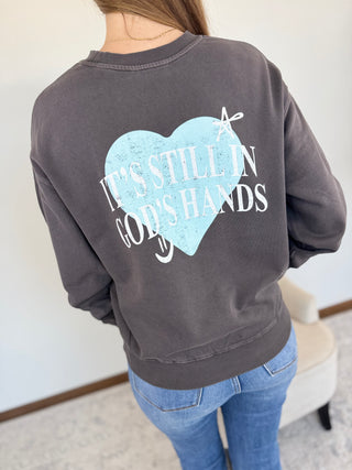 Person wearing a gray sweatshirt with a heart design and text on the back.