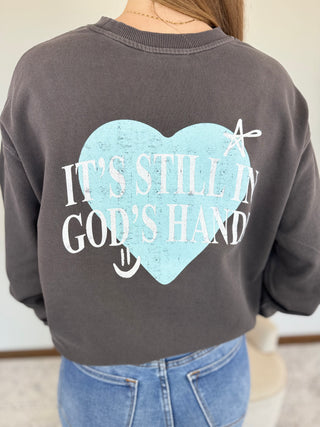 Gray sweatshirt with a heart design and text on the back, worn by a person.