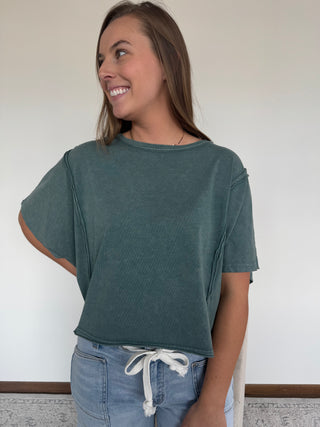 Woman wearing a green t-shirt.
