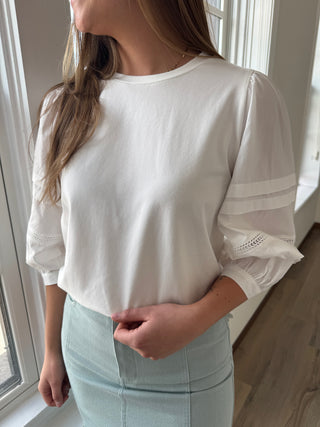 Model is wearing a white blouse.