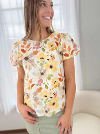 Woman wearing a floral blouse with a neutral background