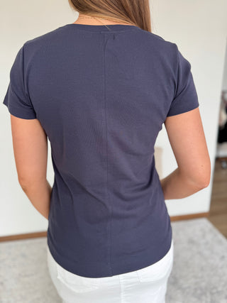 Person wearing a navy blue t-shirt in an indoor setting