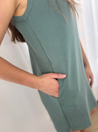 Person wearing a green dress with a plain background