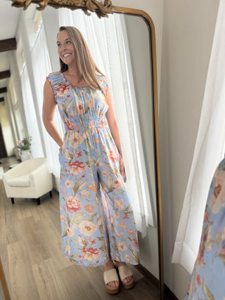 Model is wearing a floral jumpsuit.