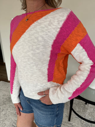 lady wearing a summer sweater in ivory, tangerine and hot pink.