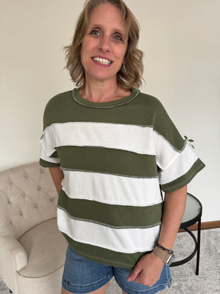 Lady wearing a stripe top in olive and cream.
