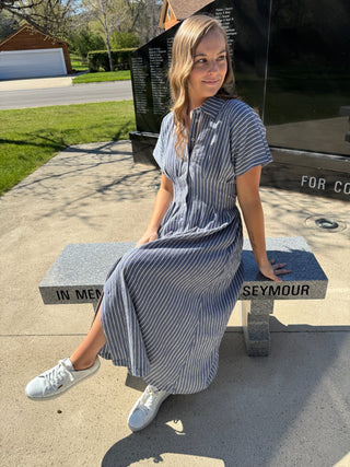 Woman wearing a blue and white striped maxi dress for Memorial Day.