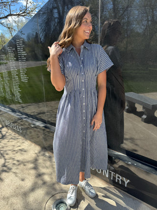 Woman wearing a blue and white striped maxi dress for Memorial Day.
