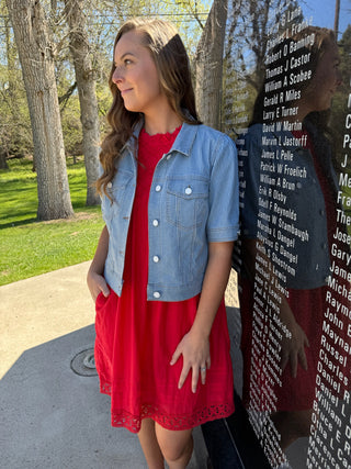 Woman wearing a red dress with a pinstripe denim jacket for Memorial Day.