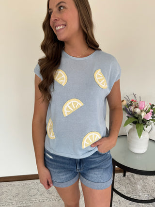 Woman wearing a top with lemon wedges on it.