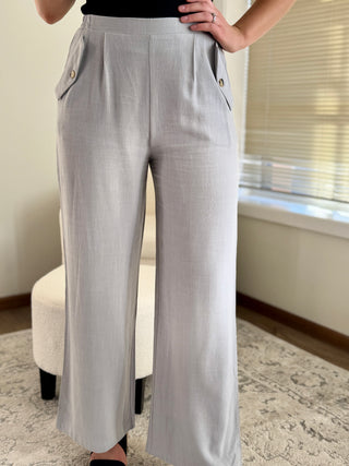 Lady wearing light blue linen pant with button front pocket.