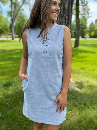 Woman wearing a light blue dress standing in a park