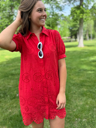 Woman wearing a red dress with a floral pattern in a park setting