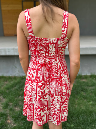 Person wearing a red and white patterned dress outdoors.