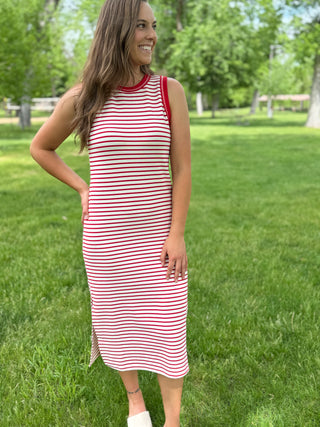 Woman wearing a red and white striped dress standing in a park.