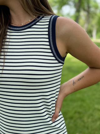 Person wearing a striped tank top with a blurred green background