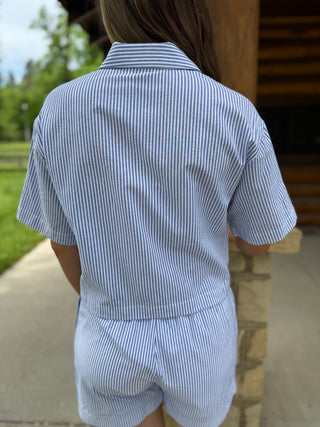 Person wearing a blue and white striped outfit walking outdoors.