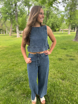 Woman wearing a blue striped outfit standing in a grassy field