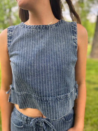 Person wearing a blue striped sleeveless top outdoors