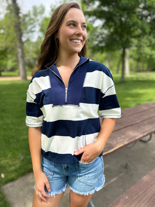 Woman wearing a navy and white striped shirt in a park setting
