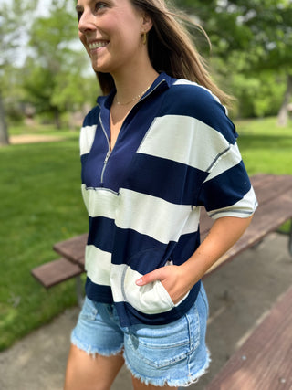 Woman wearing a navy and white striped shirt in a park setting