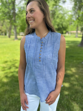 Woman wearing a blue striped sleeveless top in a park setting