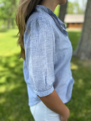 Person wearing a blue striped shirt in a park setting