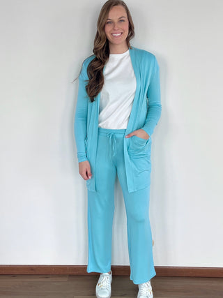 Lady standing wearing a blue terry cardigan.