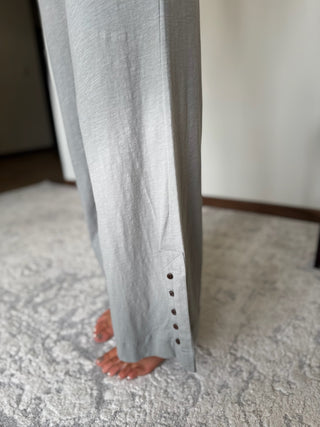 Gray pants with button details on a carpeted floor