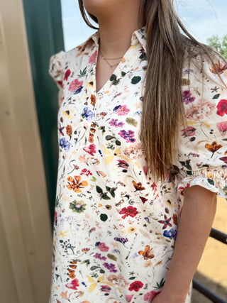 Person wearing a floral blouse with a blurred background