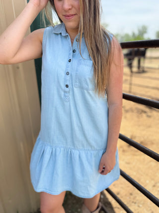 Woman wearing a light blue dress with a blurred outdoor background