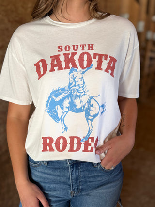 Person wearing a white t-shirt with 'South Dakota Rodeo' graphic design.