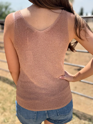 Person wearing a brown tank top and blue shorts outdoors