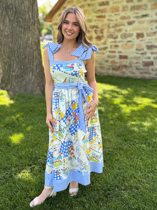Woman wearing a colorful dress with cartoon characters in an outdoor setting.