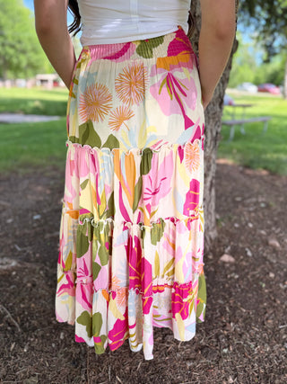 Person wearing a colorful floral skirt in an outdoor setting