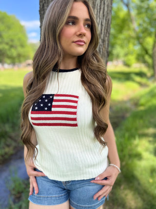 Model standing next to a tree wearing an american flag tank.