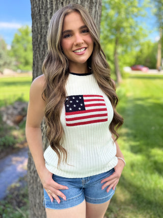Model standing next to a tree wearing an american flag tank.