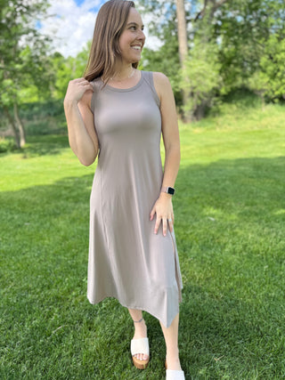 model standing in grass wearing a ribbed tank dress.