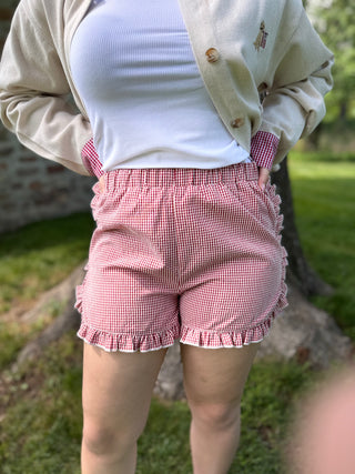 Model wearing red gingham shorts.
