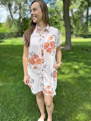 model standing in grass wearing a floral dress.