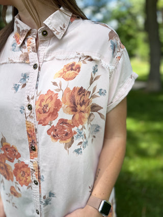 model standing in grass wearing a floral dress.